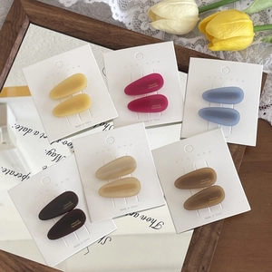 Close-up of matte waterdrop hair clips in multiple colors on elegant display cards