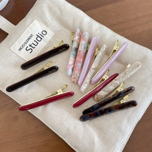 French style acetate hair clips in multiple colors and textures on a canvas bag background