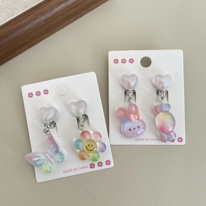 Close-up of rainbow gradient flower and heart clip-on earrings with glitter resin finish