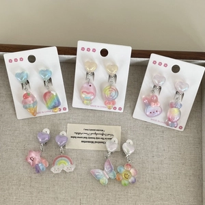 Detail view of colorful macaron resin clip-on earrings with rainbow and flower shapes