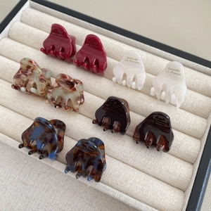 Mini pinces à cheveux en acétate de diverses couleurs sur un plateau en velours