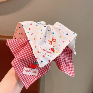 Detail of fabric scrunchie with red plaid, polka dots, and cherry embroidery accents