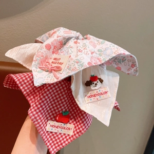 Detail of floral and plaid scrunchies with cute embroidery and woven labels