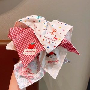 Detail of floral and plaid fabric scrunchies with cute embroidery and decorative charms