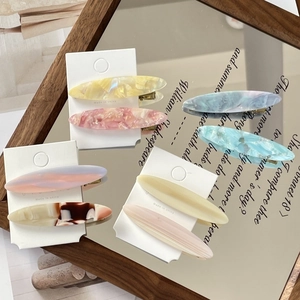 Detail of colorful marble acetate duckbill hair clips on premium packaging cards