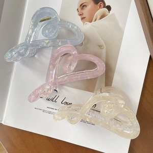 Three elegant heart-shaped claw clips in icy blue, pink, and cream pearlescent colors