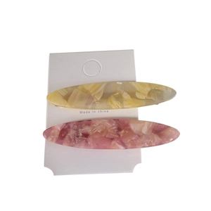 Set of two oval acetate hair clips in yellow marble and purple floral patterns