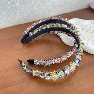 Set of two colorful bohemian woven headbands with anti-slip teeth on a wooden surface