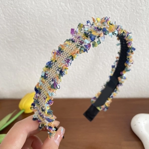 Macro detail of colorful woven fabric headband with ethnic fringe edges and textured surface