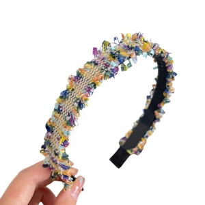 Colorful woven headband with fringed edges and multi-color yarn for a bohemian style