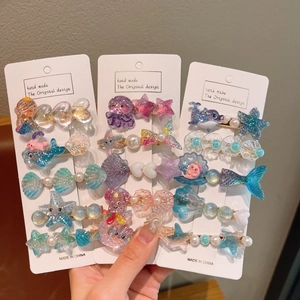 Détail de 15 barrettes de mer avec coquillages et étoiles de mer en résine pailletée