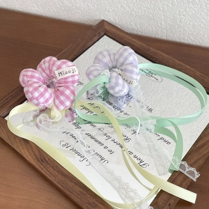 Detail of plaid scrunchies with elegant ribbon streamers and floral lace embroidery