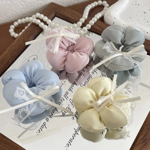 Vue détaillée de quatre chouchous de couleur pastel avec des accents de nœuds en dentelle