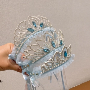 Close-up of light blue lace tiara with silver frame and marquise-cut blue gemstones