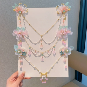 Détail de pinces à cheveux traditionnelles avec fleurs en résine rose et glands perlés