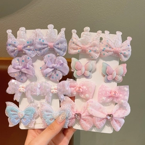 Close-up of cute purple and pink girls hair clip set with bows and crowns