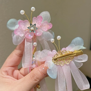 Détail de pinces Hanfu avec ailes en organza bleu, pétales roses et pompons en soie