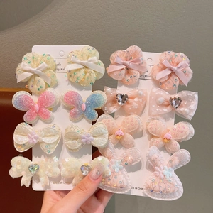 Detail of sweet children hair clips with bows, flowers and sequins on paper cards