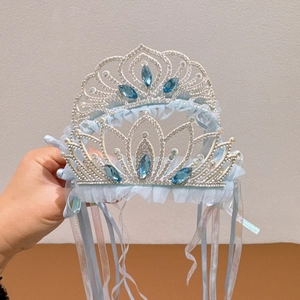 Detail of princess crown headband with blue rhinestones, lace trim and colorful ribbons
