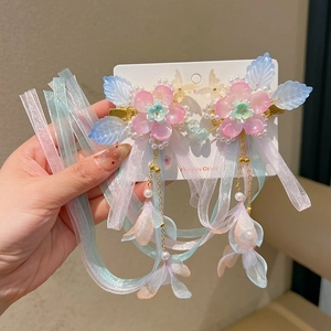 Détail de pinces à cheveux fleur avec rubans en dégradé et glands en perles