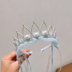 Detailed close-up of crown headband with silver metal frame, white pearls and blue lace detail