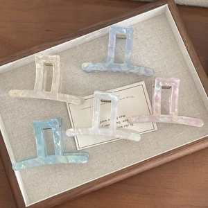 Close-up of geometric acetate hair claws in pastel Morandi colors with marble texture