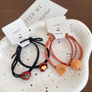 Elastici per capelli con ciondoli a forma di pomodoro e zucca su vassoio in ceramica