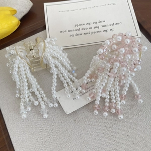 Detailed close-up of pearl bead tassel hair claws with clear acrylic and elegant hanging beads