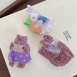 Detail of three cute animal hair claws featuring a bunny, bear, and squirrel design