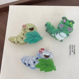 Detailweergave van schattige rups haarklemmen van acryl in geel, groen en blauw