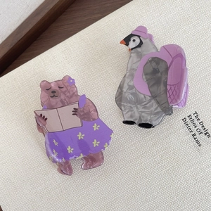 Detailed macro of acetic acid hair claws featuring cute cartoon bear and penguin designs