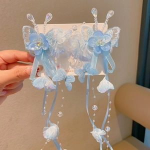 Detailed view of light blue butterfly embroidery hair clips with long beaded tassels