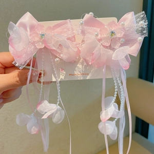 Detail of pink tassel hair clips with butterfly lace and floral beads for girls