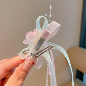 Detail of pink and mint green organza bow hair clip with pearl tassels and beads