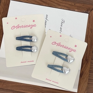Détail de barrettes en denim faites main avec perles et coeurs sur carte de support