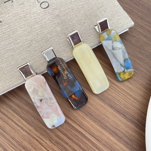French acetate hair clip set with marble texture and golden letters on wooden background