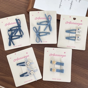 Détail de cinq paires de barrettes en denim avec nœuds, marguerites et dentelle