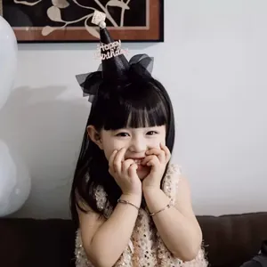 Detalle de gorro de cumpleaños negro con purpurina para niños y texto Happy Birthday dorado