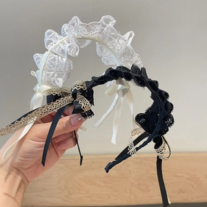 Detalle de diademas de encaje con lazos, perlas y cintas largas en blanco y negro