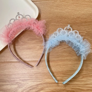 Detailed close-up of pink and blue lace headbands with sparkling rhinestone crown accents