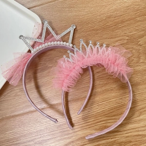Close-up of kids' crown headbands with sparkling rhinestones and delicate lace mesh
