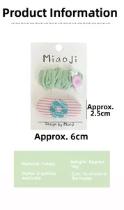 Détail de broderies florales et barrettes BB vertes pour filles en lot de deux