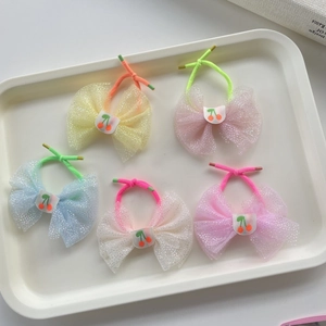 Detail of 5-piece kids hair ties with mesh bows and cherry embroidery in pastel colors