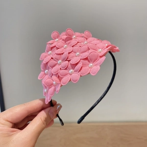Detail shot of the pink floral hairband with white pearls and slim black metal frame