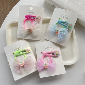 Close-up of children's mesh bow hair ties and colorful floral metal hair clips set
