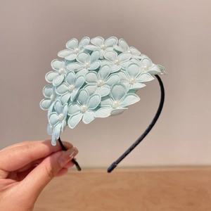 Detail of light blue fabric flower headband with pearl centers for girls hair
