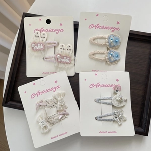 Detail von vier Sets handgefertigter Haarklammern mit rosa Hasenohren und Spitzenschleifen
