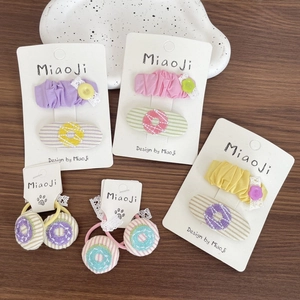 Détail des barrettes brodées et élastiques avec dentelle et boutons colorés pour fille