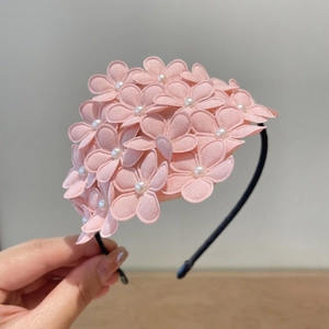 Detailed view of handmade pink floral headband with white pearls and black frame