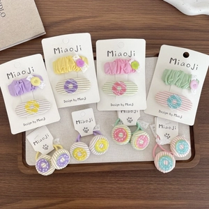 Détail de barrettes BB brodées et d'élastiques à cheveux aux couleurs de macarons